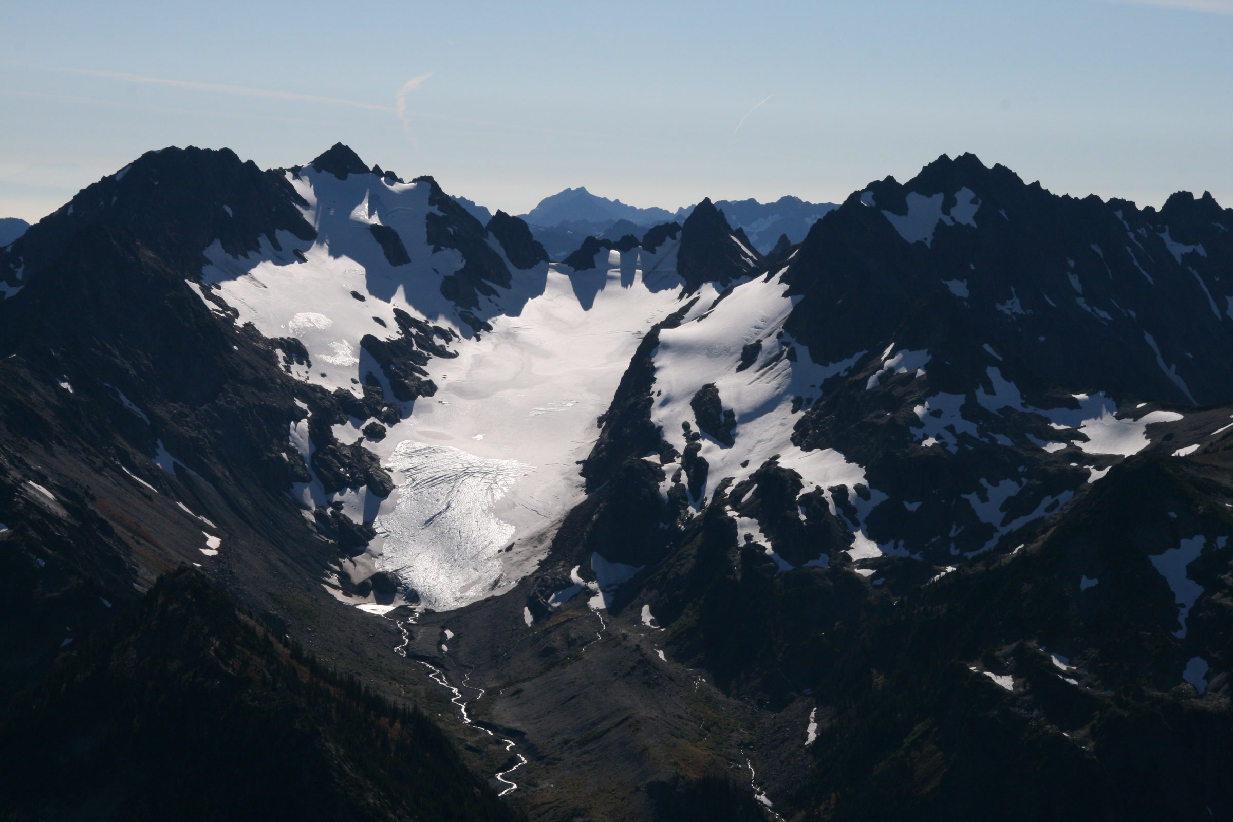Eel Glacier on Mount Anderson in October 2010, a small white ice field between jagged dark peaks, photographed on a park glacier monitoring flight