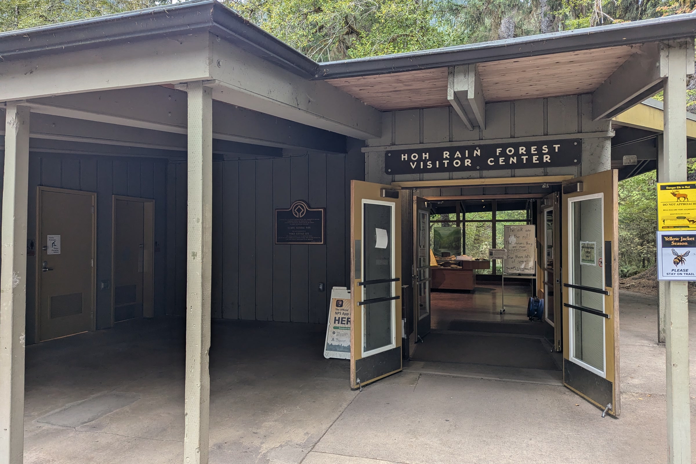 The covered entrance of the Hoh Rain Forest Visitor Center, with open double doors and a broad concrete walkway