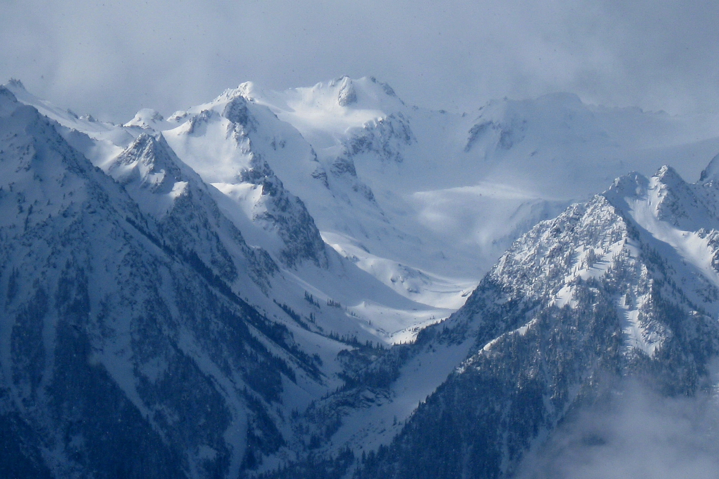 Glaciers and snowfields on Mount Carrie in the Olympic Mountains, with cloud drifting across the ridges